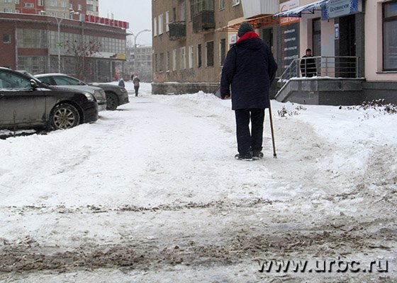Людям приходится идти по краю «расчищенного» тротуара, чтобы не попасть на лед